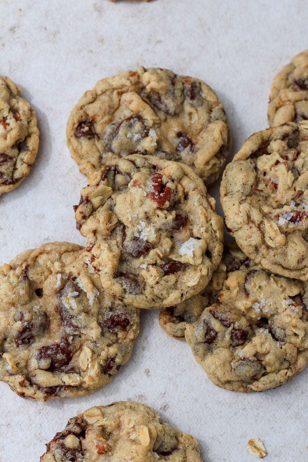 A small pile of dairy-free cowboy cookies on a brown counter .
