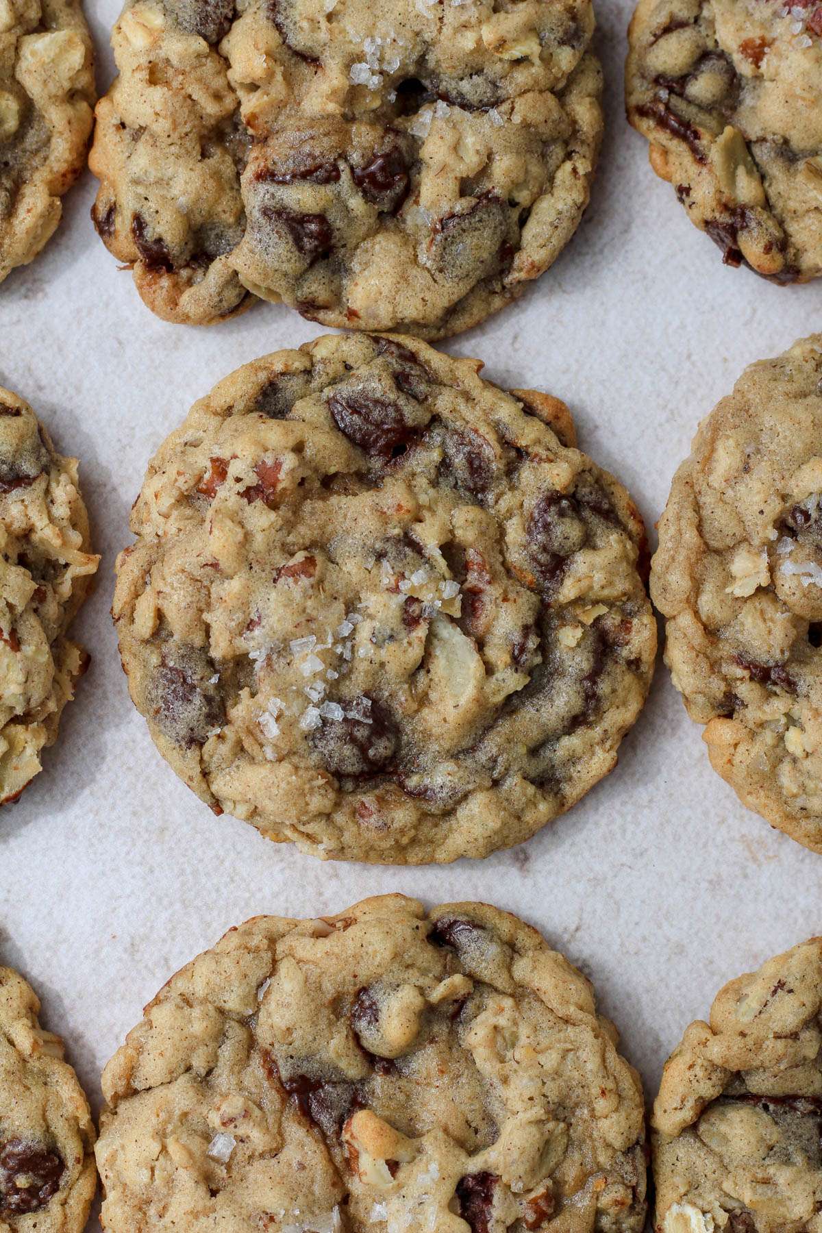 A close up of a dairy-free cowboy cookie topped with flaky sea salt.