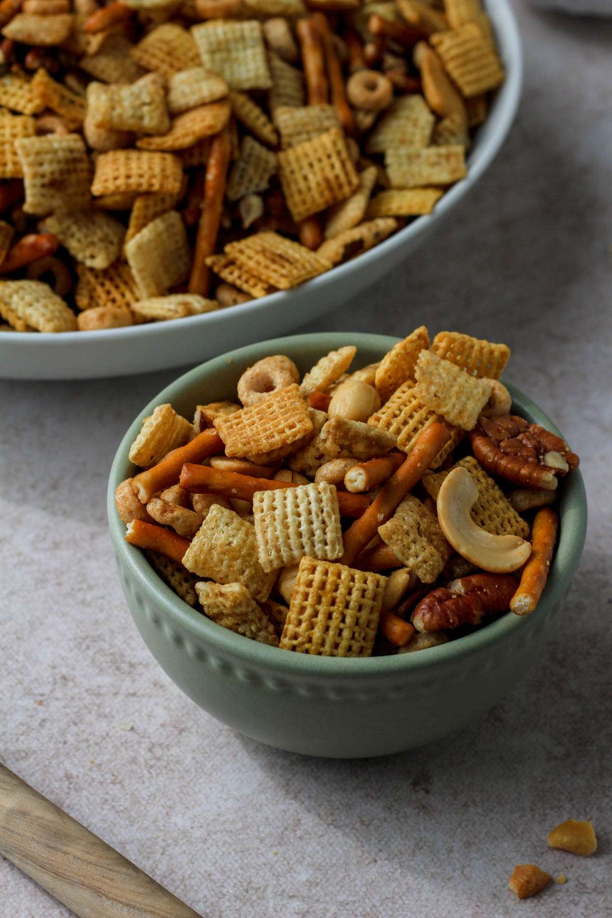 A small green bowl in front of a large white bowl both filled with dairy-free texas trash.