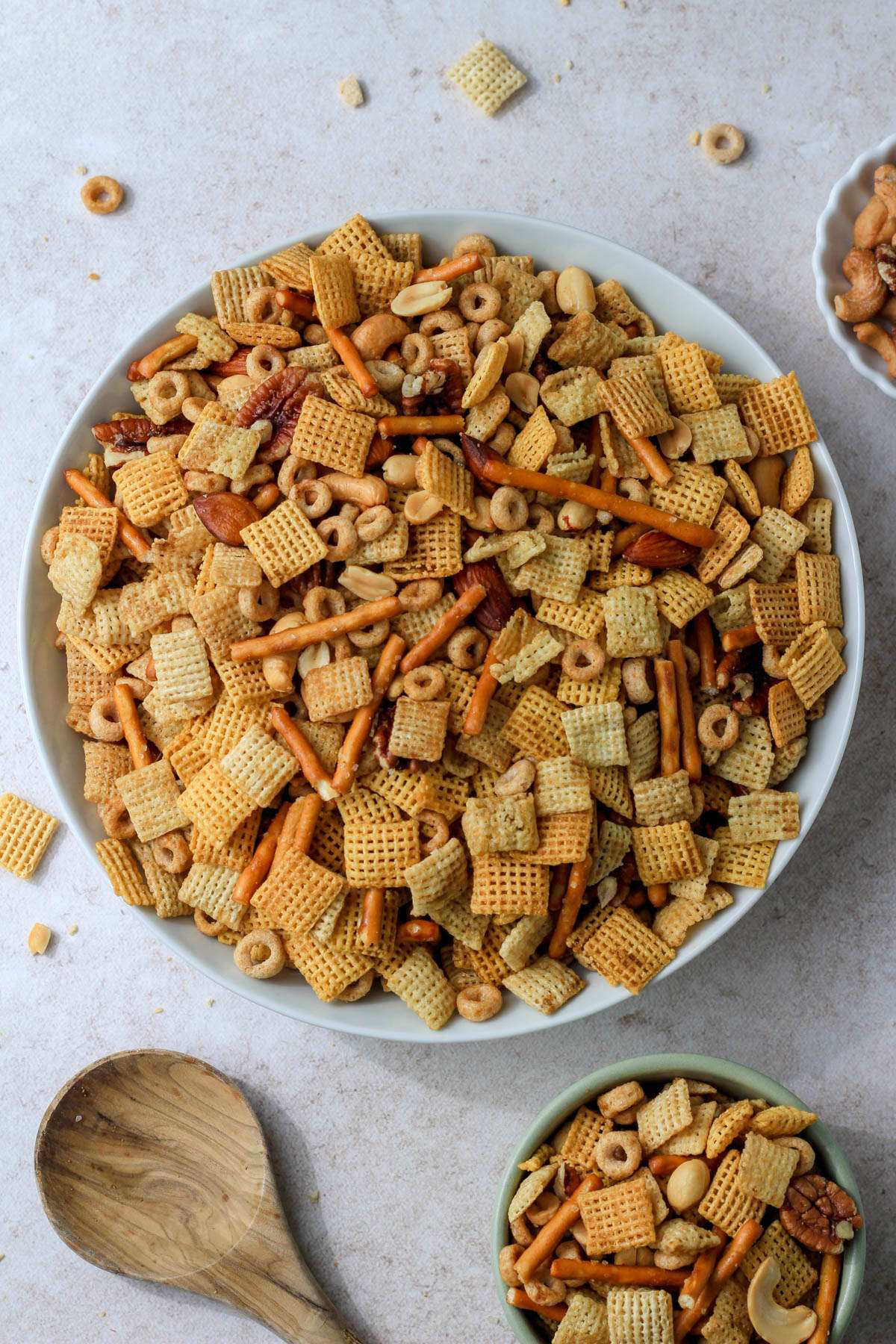 A top down image with a white bowl filled with dairy-free Texas trash and a smaller bowl in the bottom right with a wooden spoon to the bottom left.