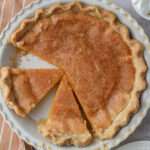 A close up of a cream pie pan with slices of dairy-free chess pie.