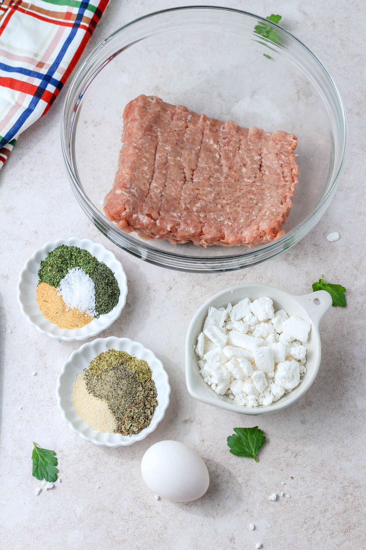 Ingredients for Greek turkey meatballs on a cream counter.