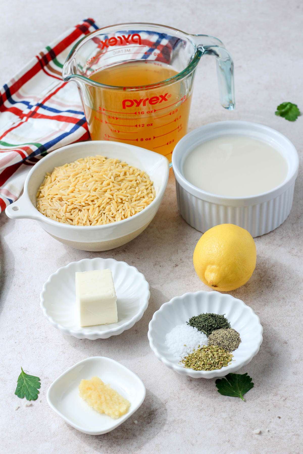 A cream counter with the ingredients for making creamy lemon orzo.