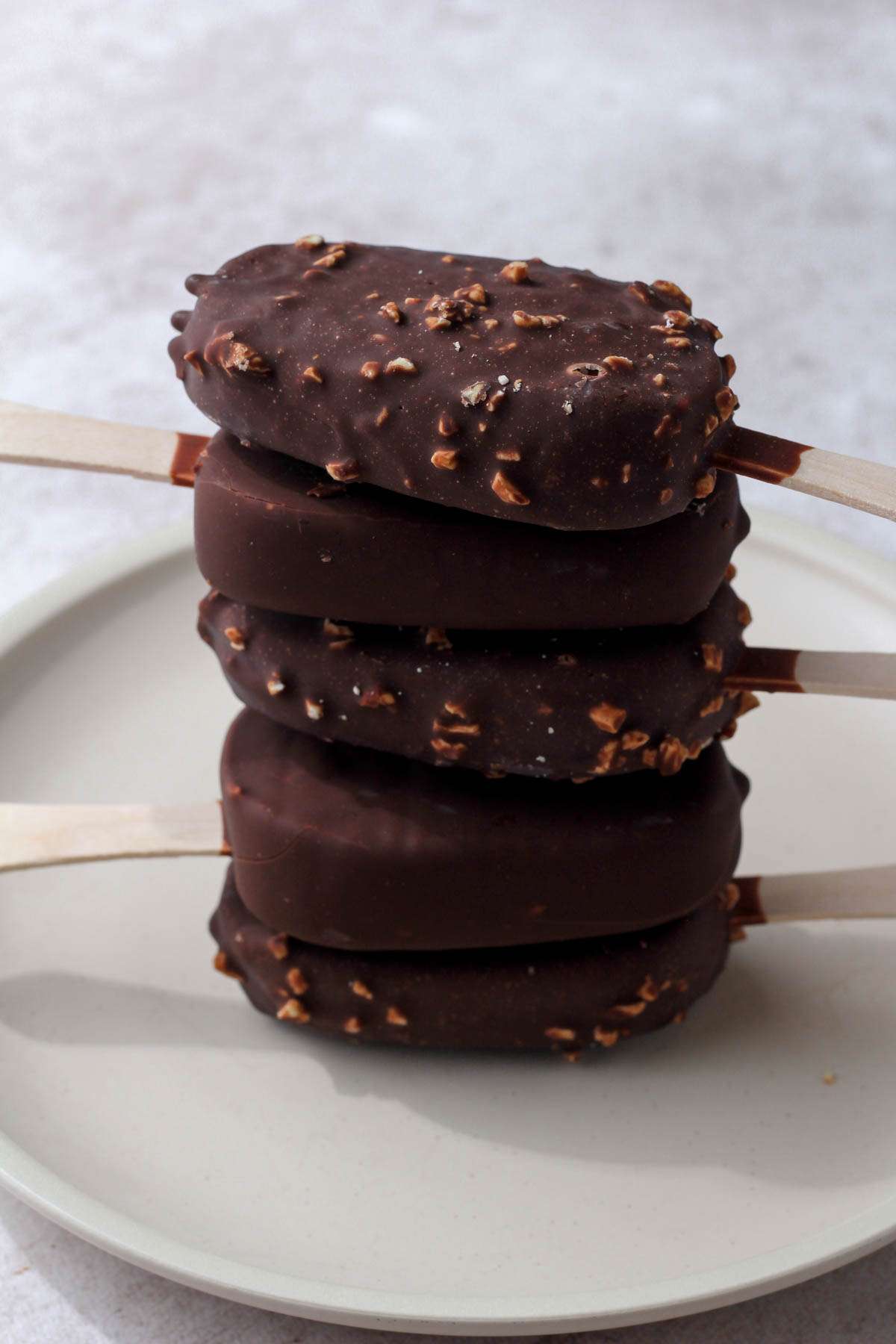 A cream plate with a stack of 5 dairy-free So Delicious Ice Cream Bars.