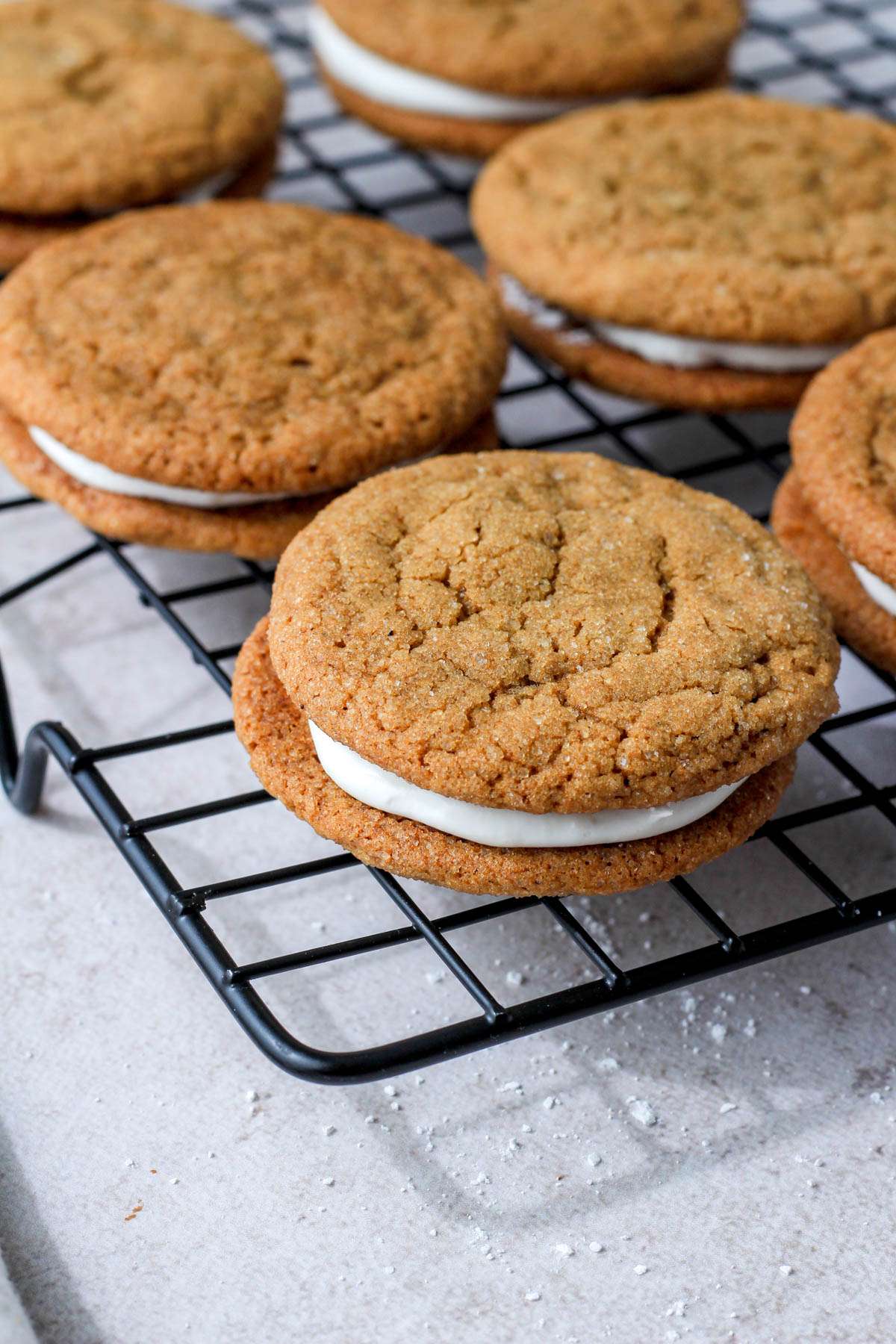 Soft ginger cream pie cookies on a black cooling rack.