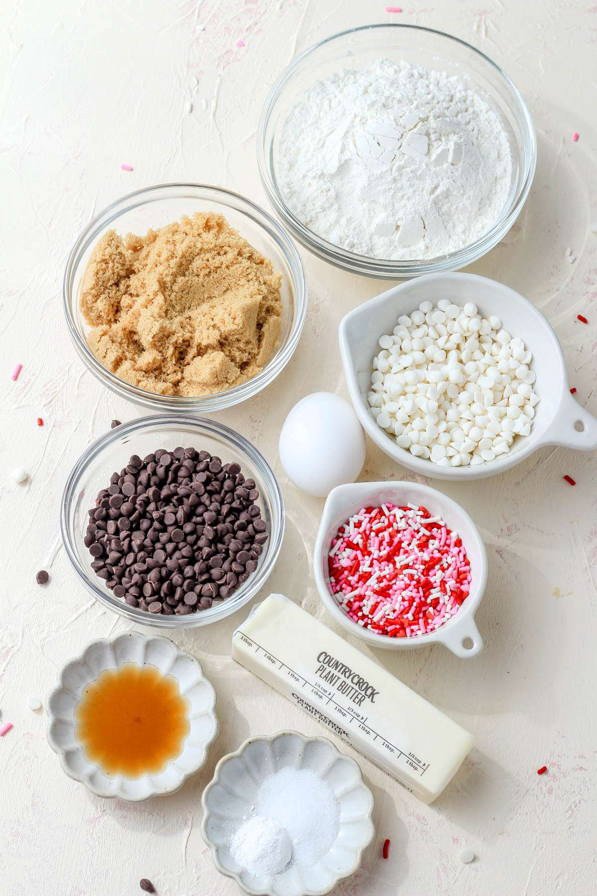Ingredients for valentines day chocolate chip cookies on a cream counter.