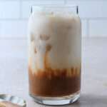 A close up of an almond milk topped chocolate shaken espresso before stirring.