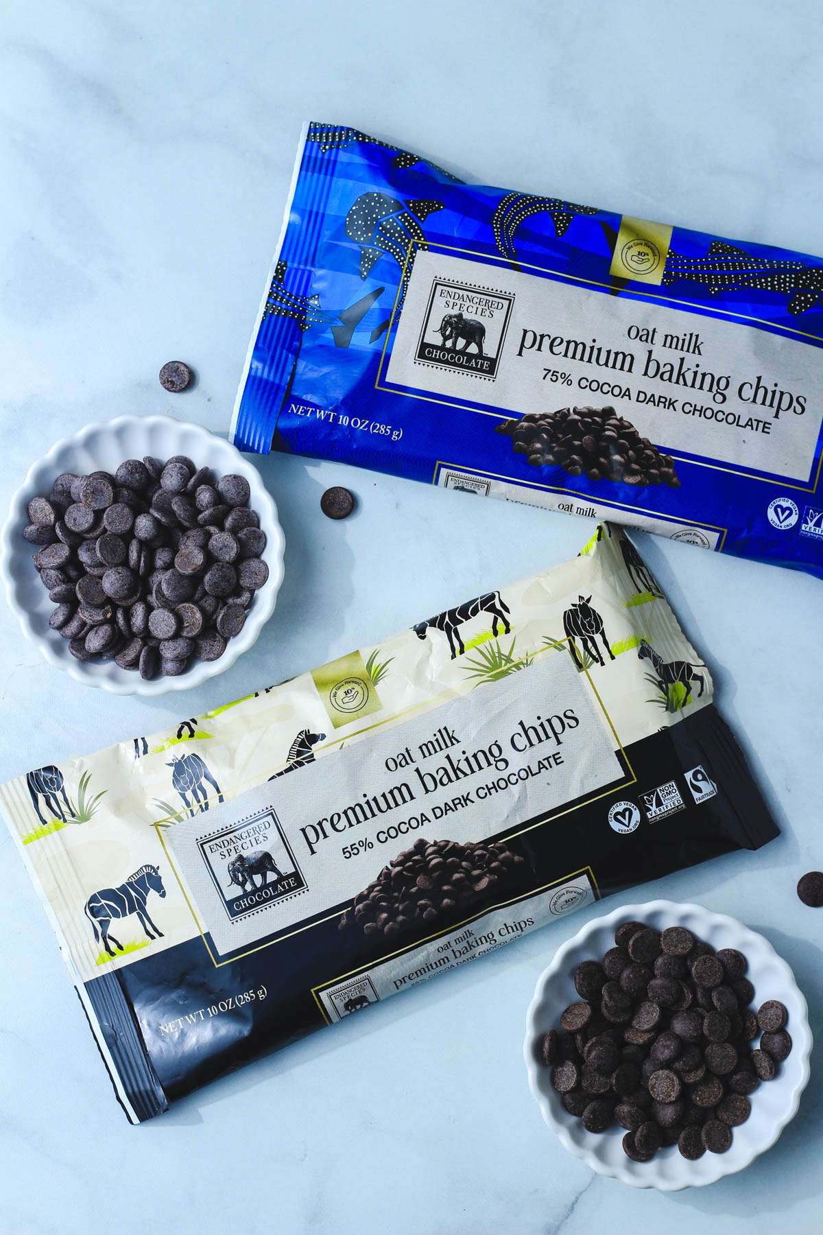 A top down image of bags of endangered species chocolate chips open and poured onto small white plates.