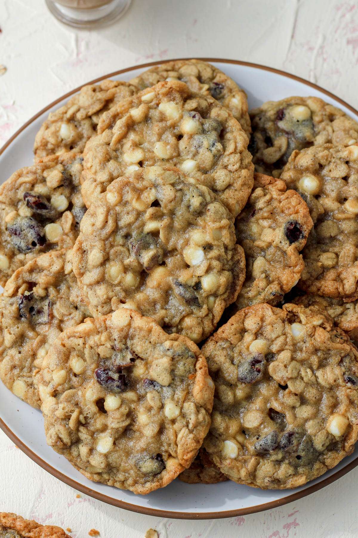 A top down photo of the cookies piled on a white plate with a brown rim.