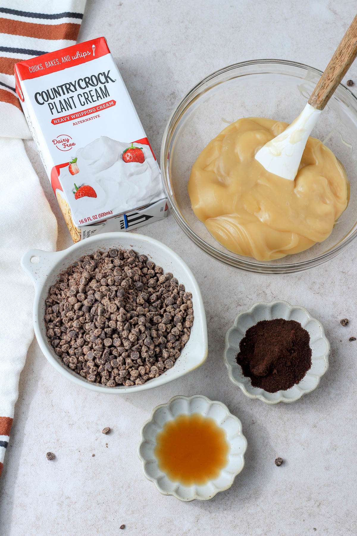 Ingredients for coffee chip no churn ice cream on a tan counter.