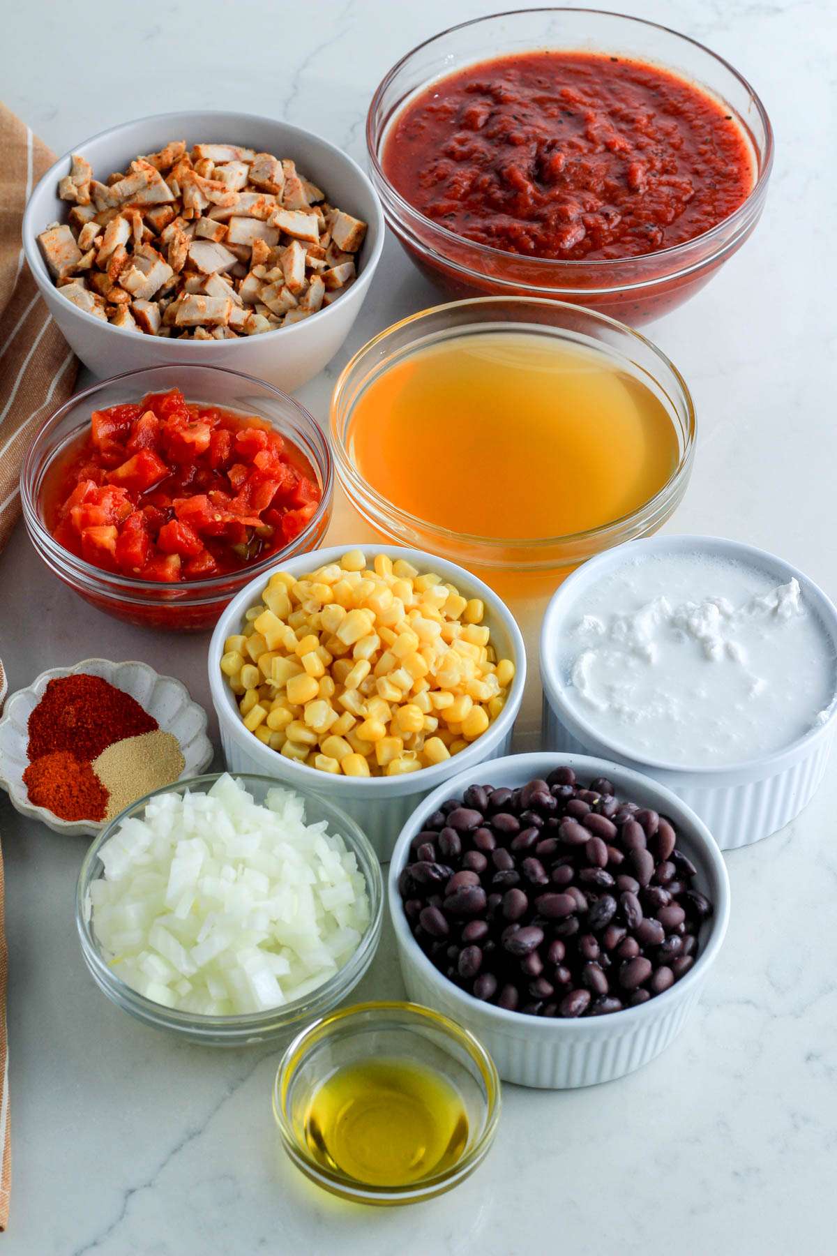 Ingredients for creamy southwest chicken tortilla soup on a white counter.