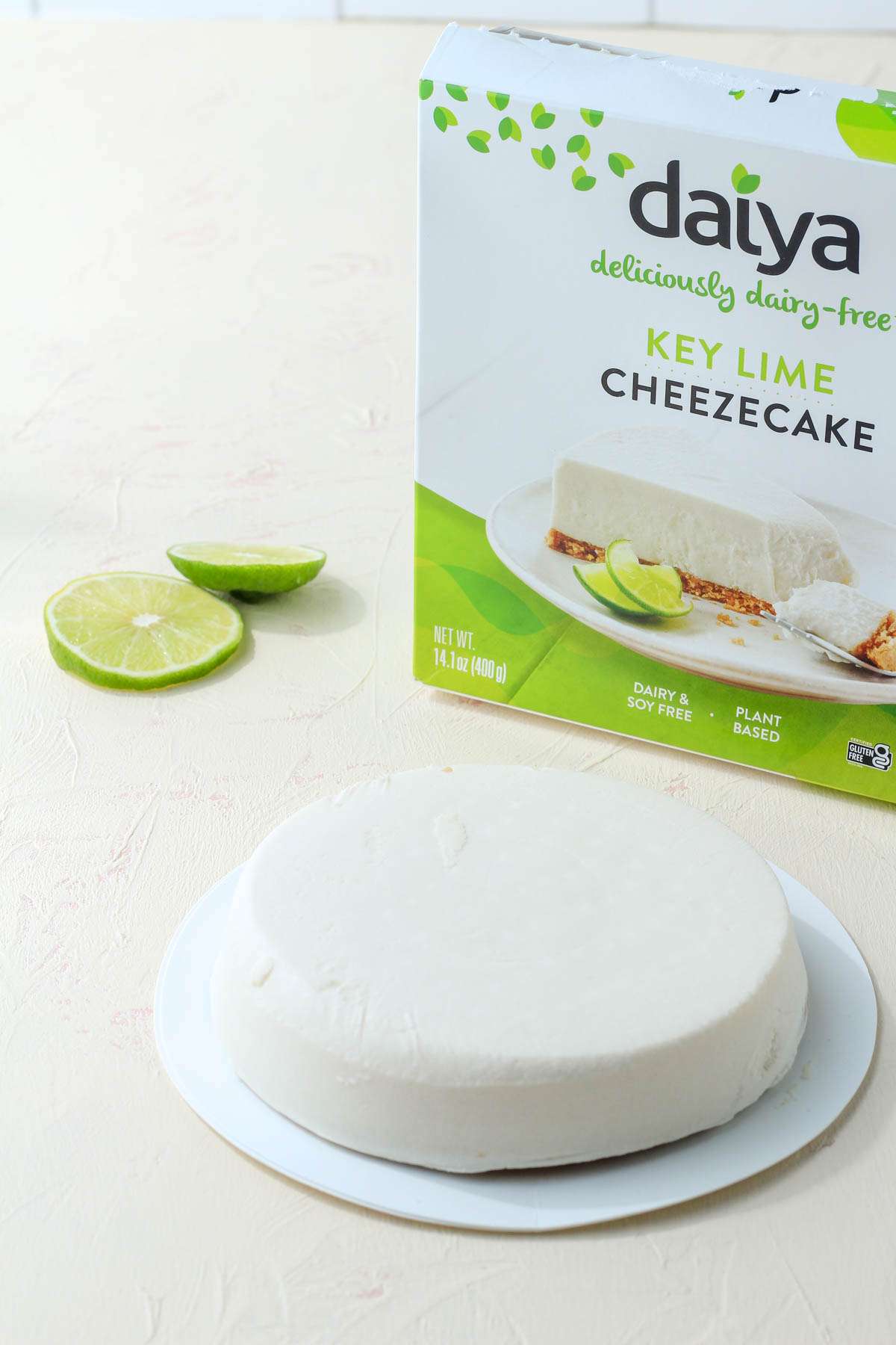 Daiya Key Lime Cheezecake out of the box on a cream counter with the box propped up in the back right corner.
