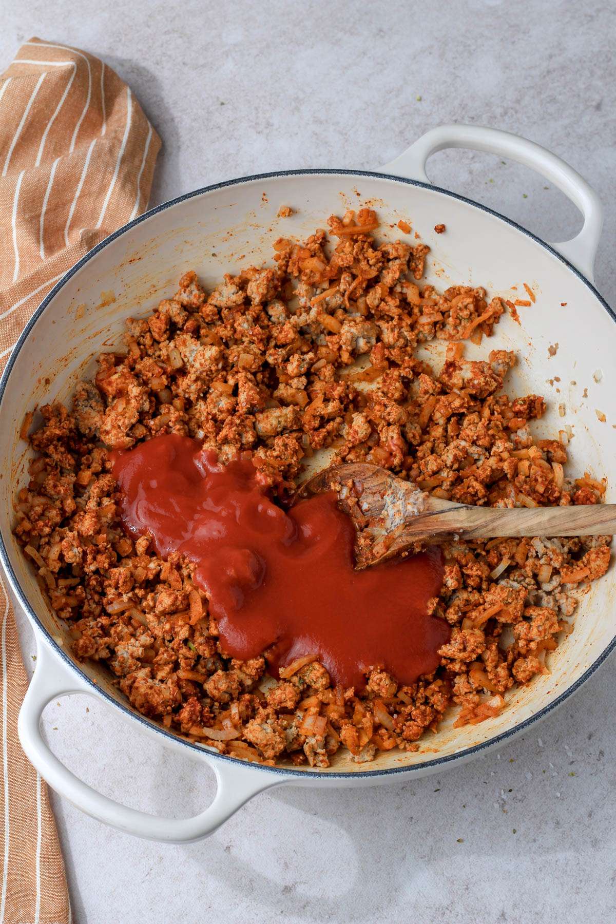 A white skillet with ground turkey taco meat before mixing the sauec in.