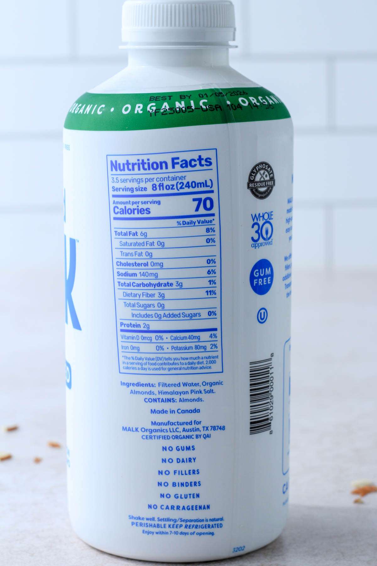 Ingredients for Malk Organics almond milk on a white counter with a white backsplash.