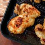 A close up of a boneless skinless chicken thigh in a non-stick grill pan after cooking.