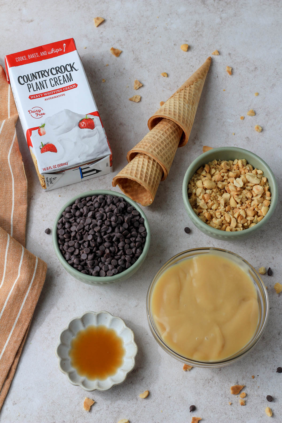 Ingredients for no churn drumstick ice cream on a tan counter.