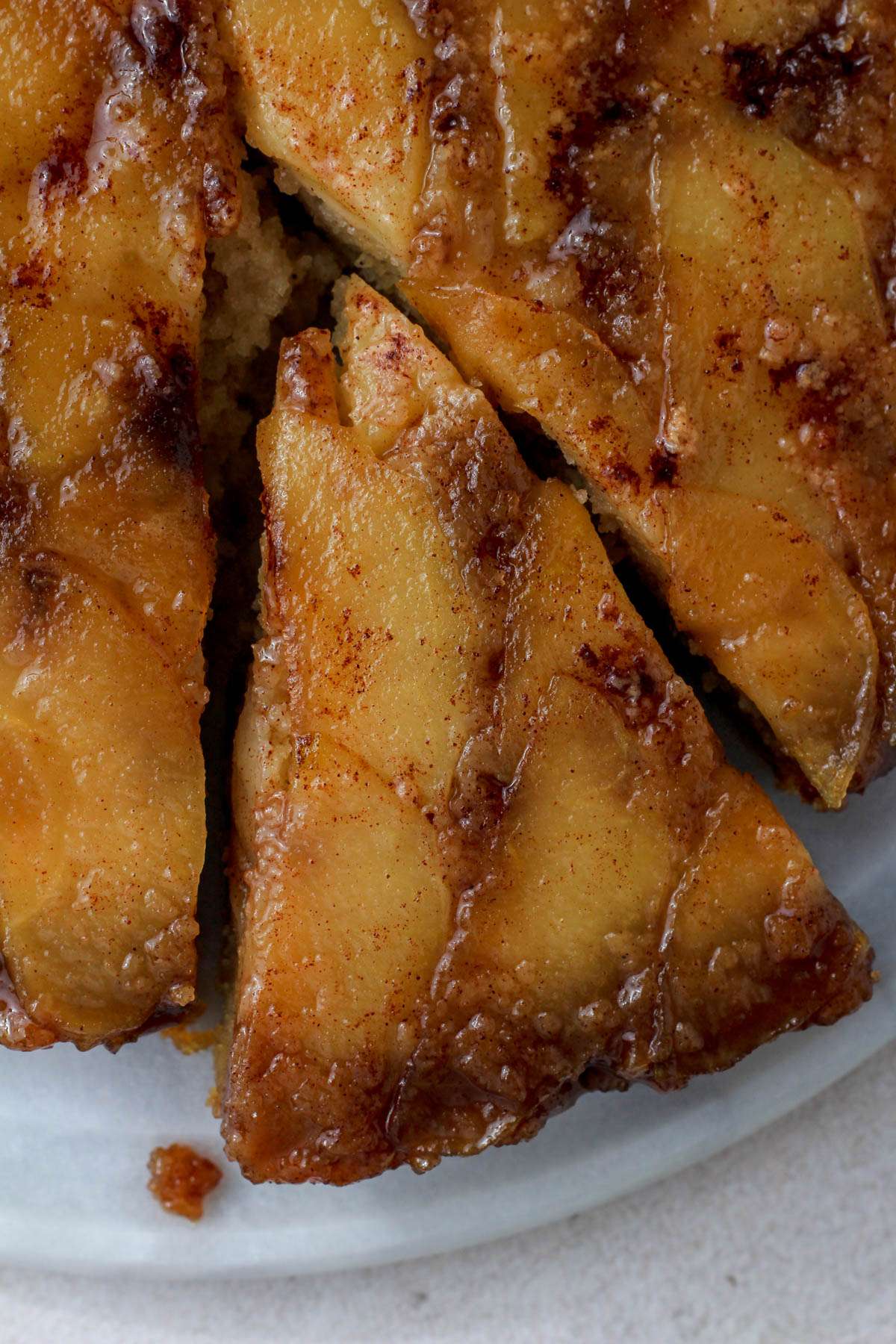 A top down picture of a cinnamon apple topped cake with a slice taken out.