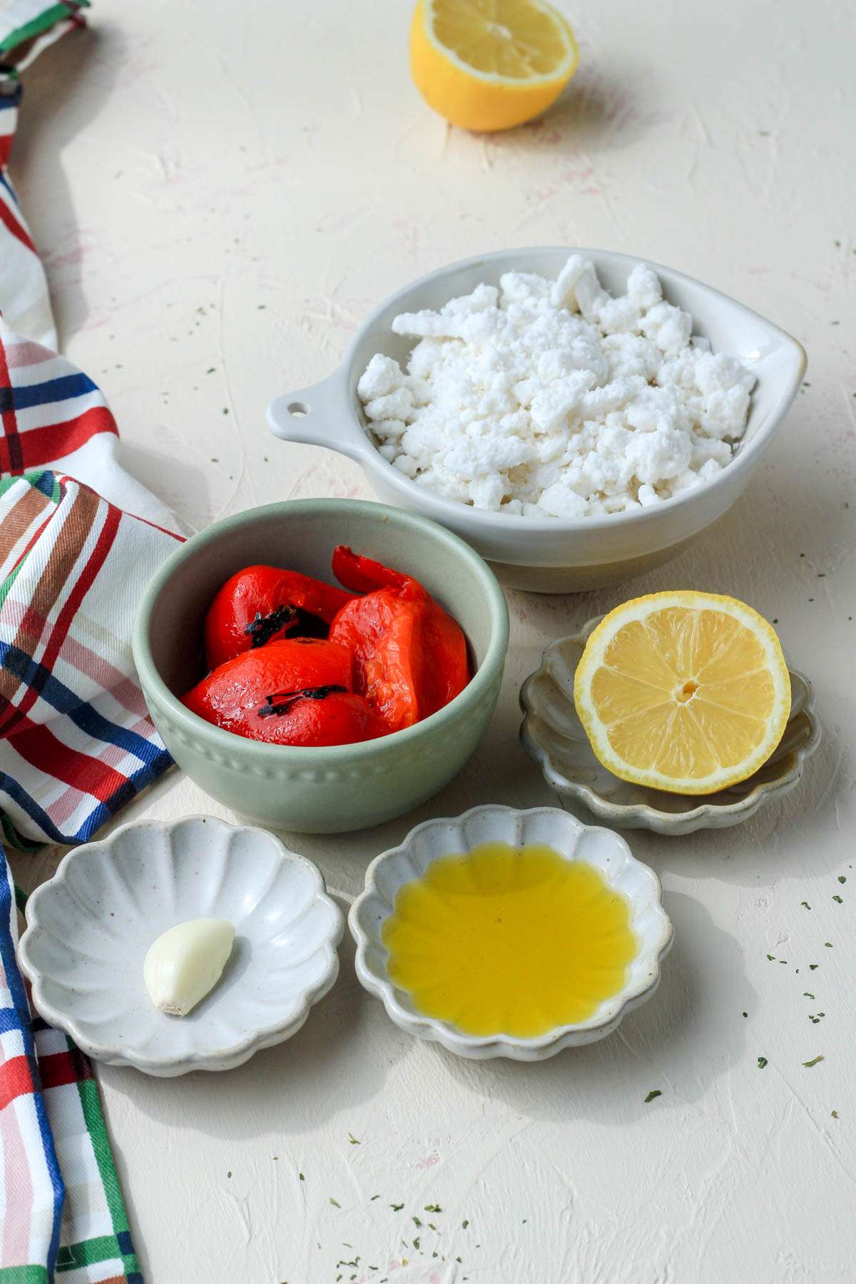 Ingredients for vegan feta and roasted red pepper dip on a tan counter.