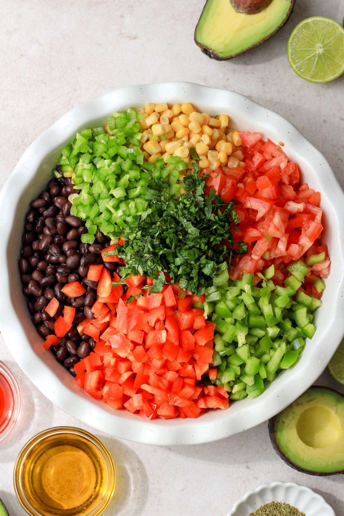 A large white dish filled with the vegetables for texas caviar before mixing together.