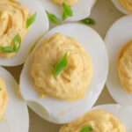 Green onion on top of a classic deviled egg.