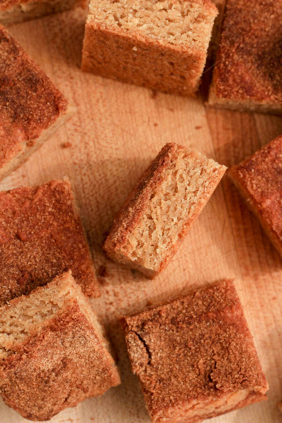 Snickerdoodle cookie bars on a wooden counter with some on their side.
