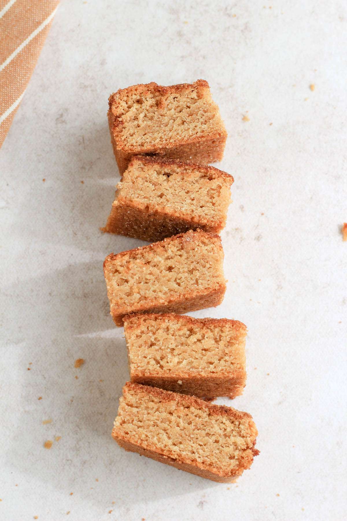 Five snickerdoodle cookie bars in a vertical line on a counter showing the moist sides of the cookie bars.