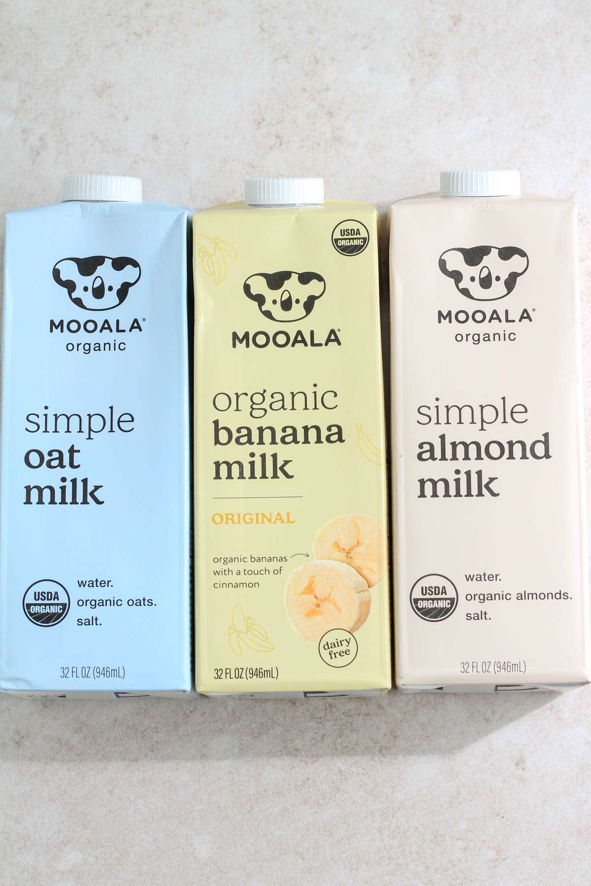 Three cartons of Mooala Milk on a cream counter.