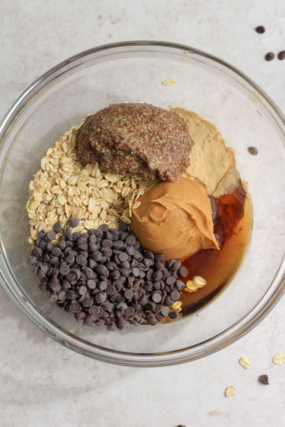 A glass mixing bowl with the ingredients for peanut butter lactation bites before mixing together.