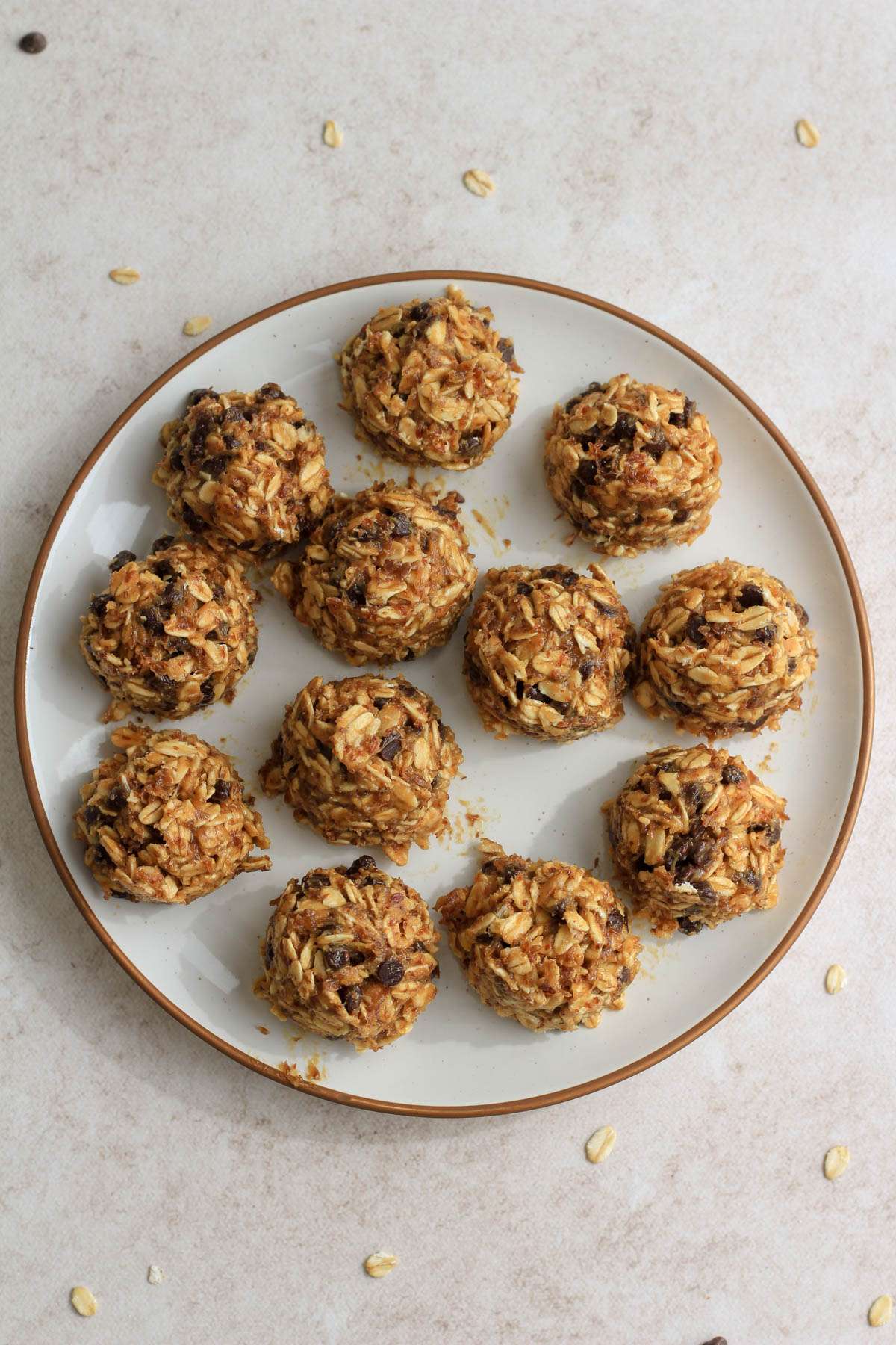 A white plate with brown rim topped with scoops of peanut butter chocolate chip lactation bites.
