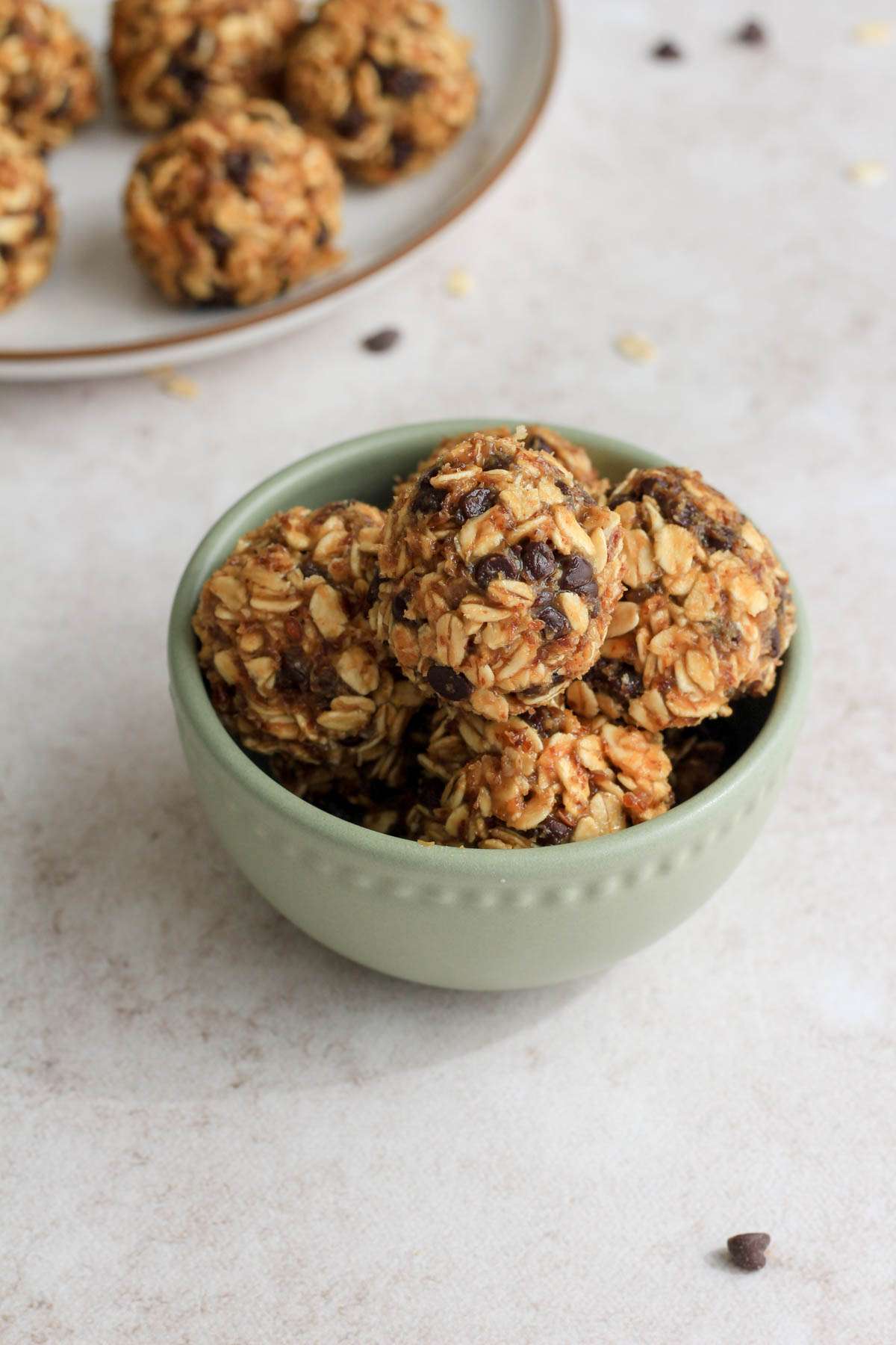 A small green bowl with balls of chocolate and peanut butter lactation bites.