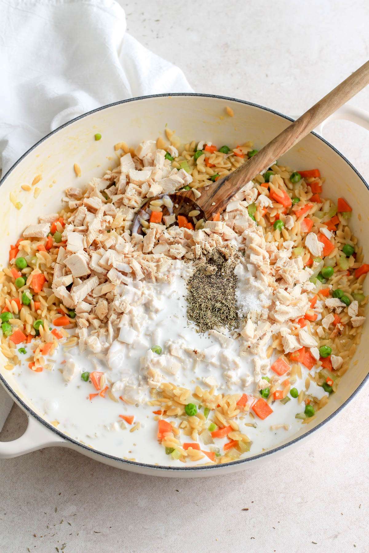 A white skillet with chicken pot pie orzo before mixing together.