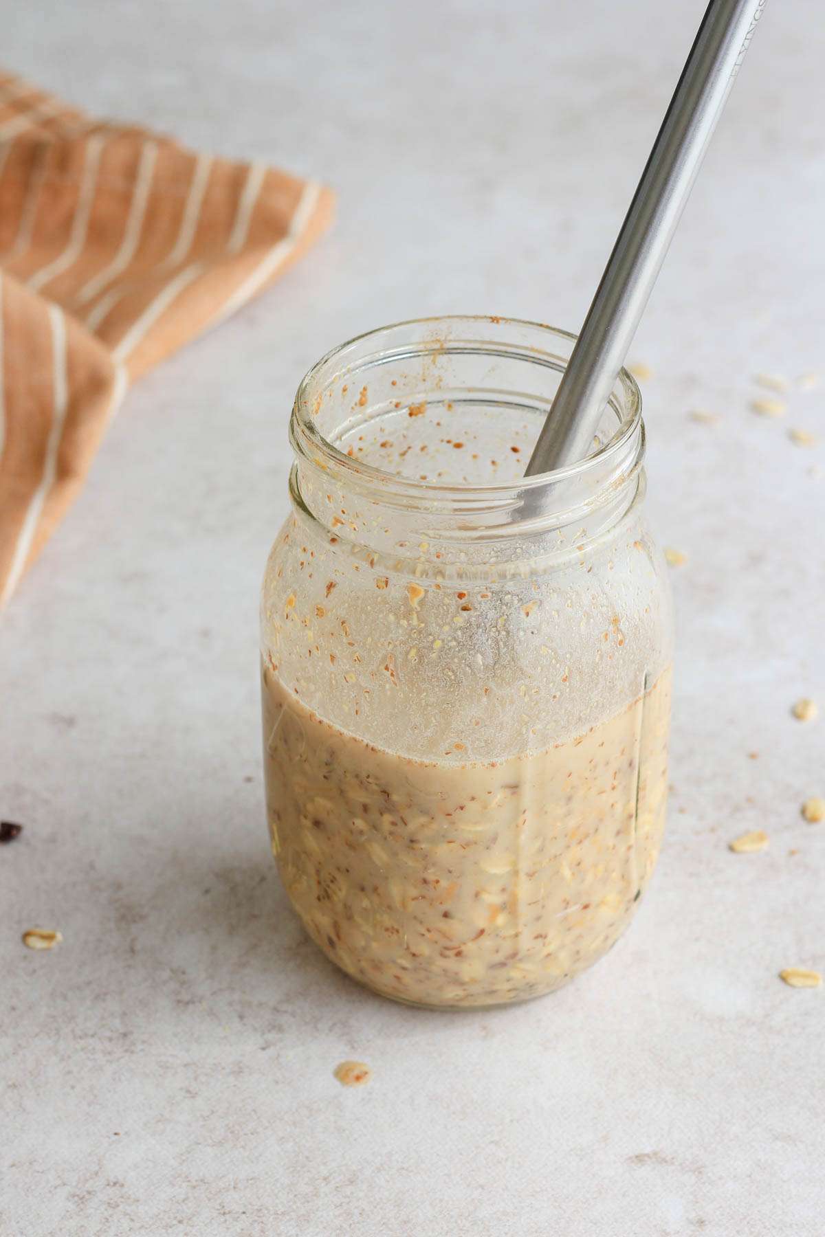 A mason jar with peanut butter overnight oats after mixing with a mini whisk.