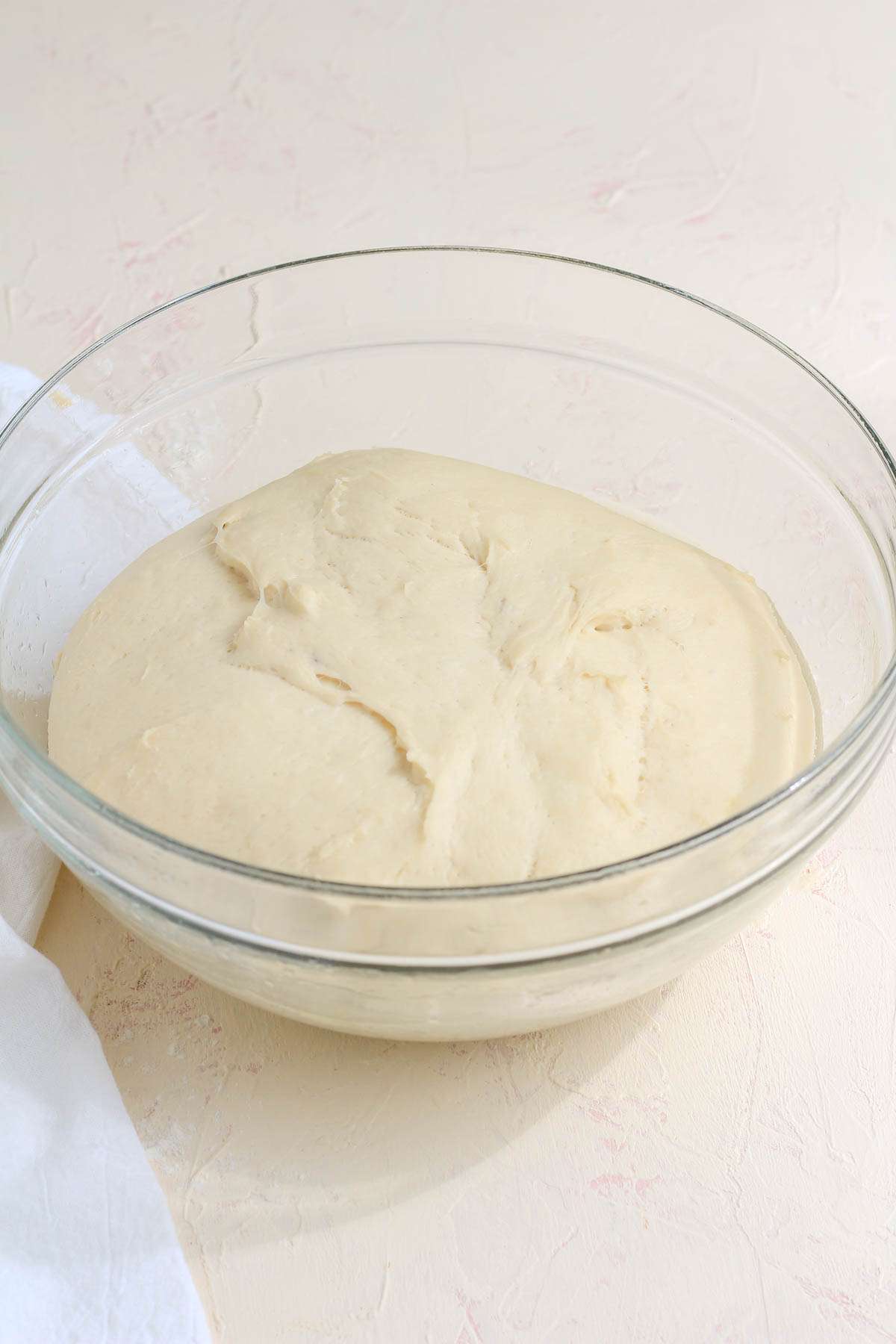 A glass bowl with vegan bread dough after rising.