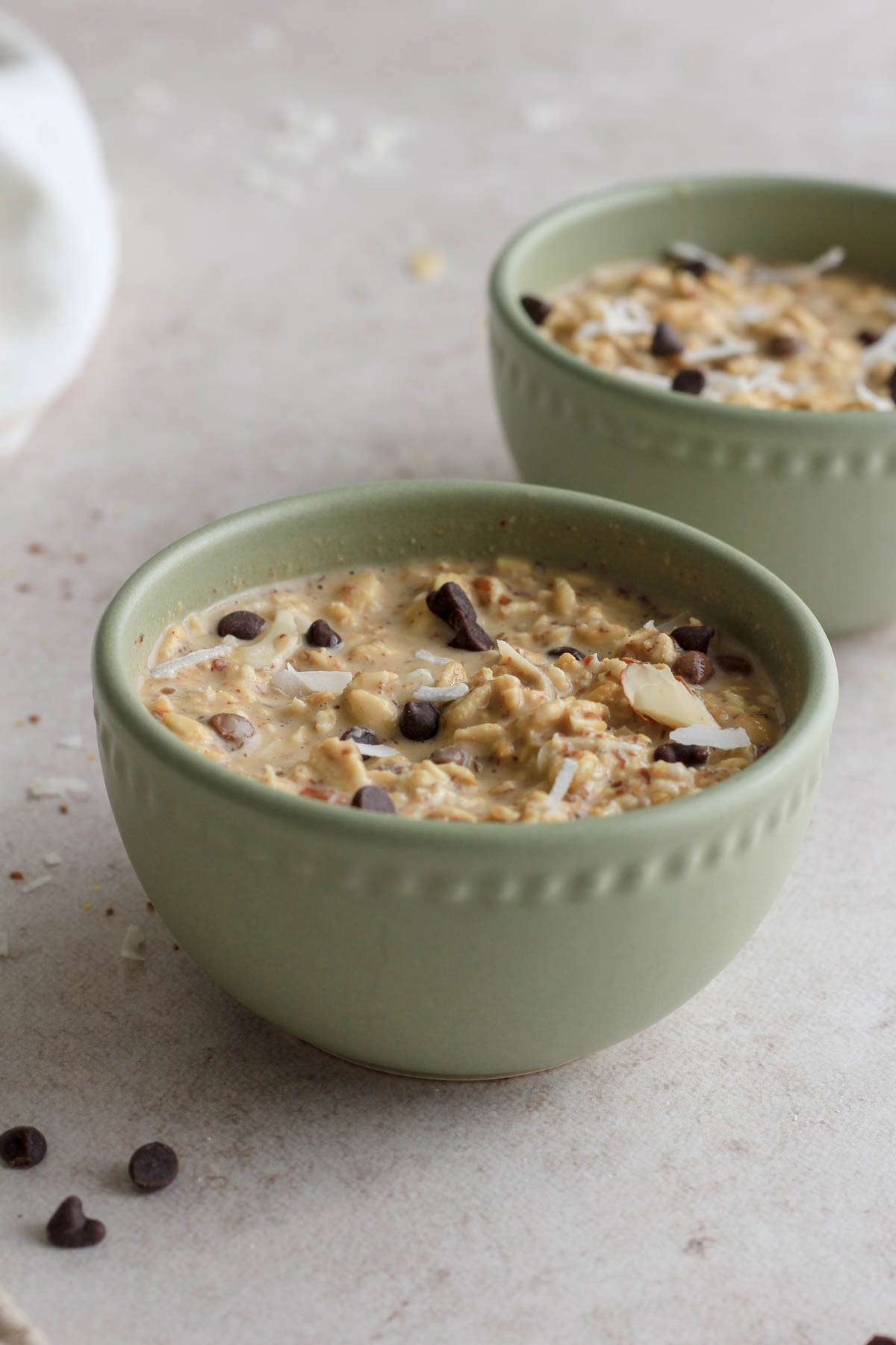 Two green bowls from the side, with almond joy overnight oats.