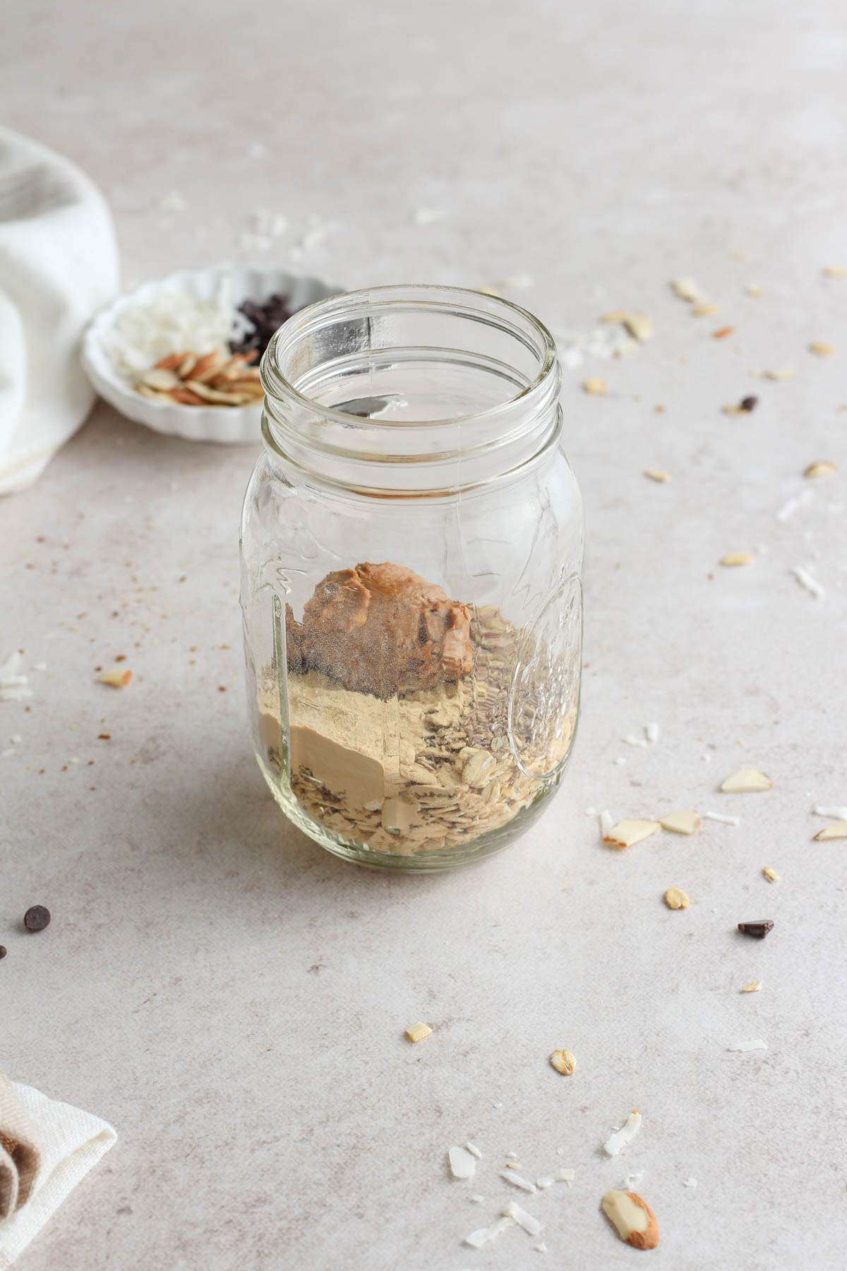 A glass mason jar with the dry ingredients for lactation overnight oats.