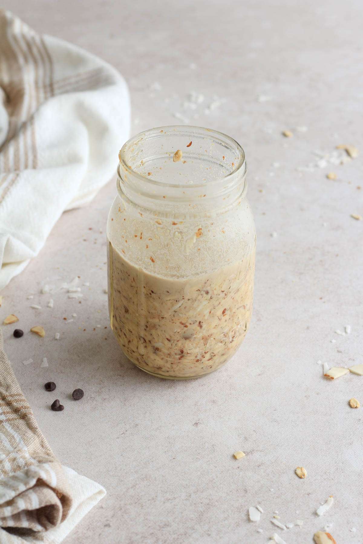 After resting overnight, almond joy lactation overnight oats in a cold glass mason jar.