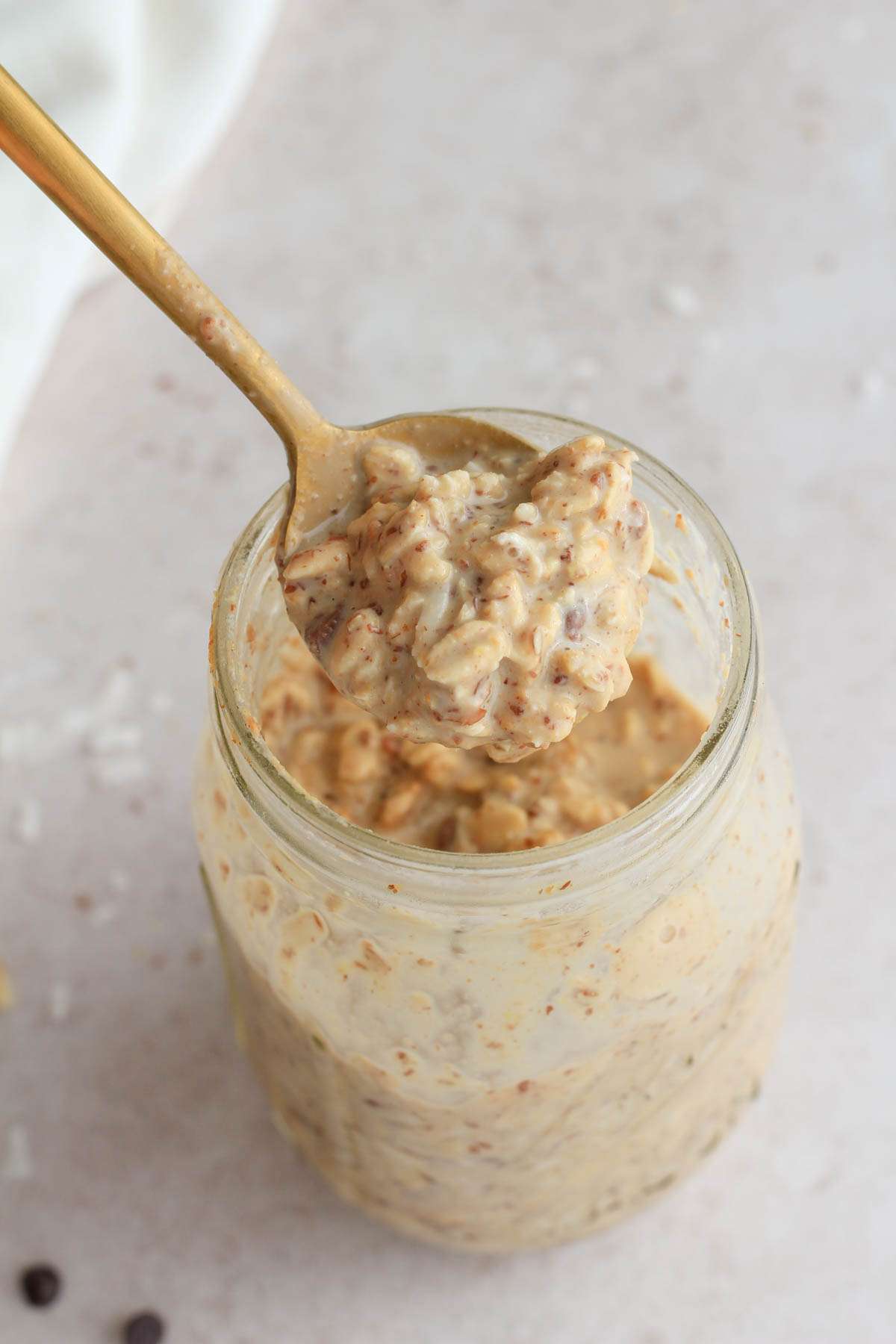 A gold spoon scooping out a heap of almond joy lactation overnight oats.