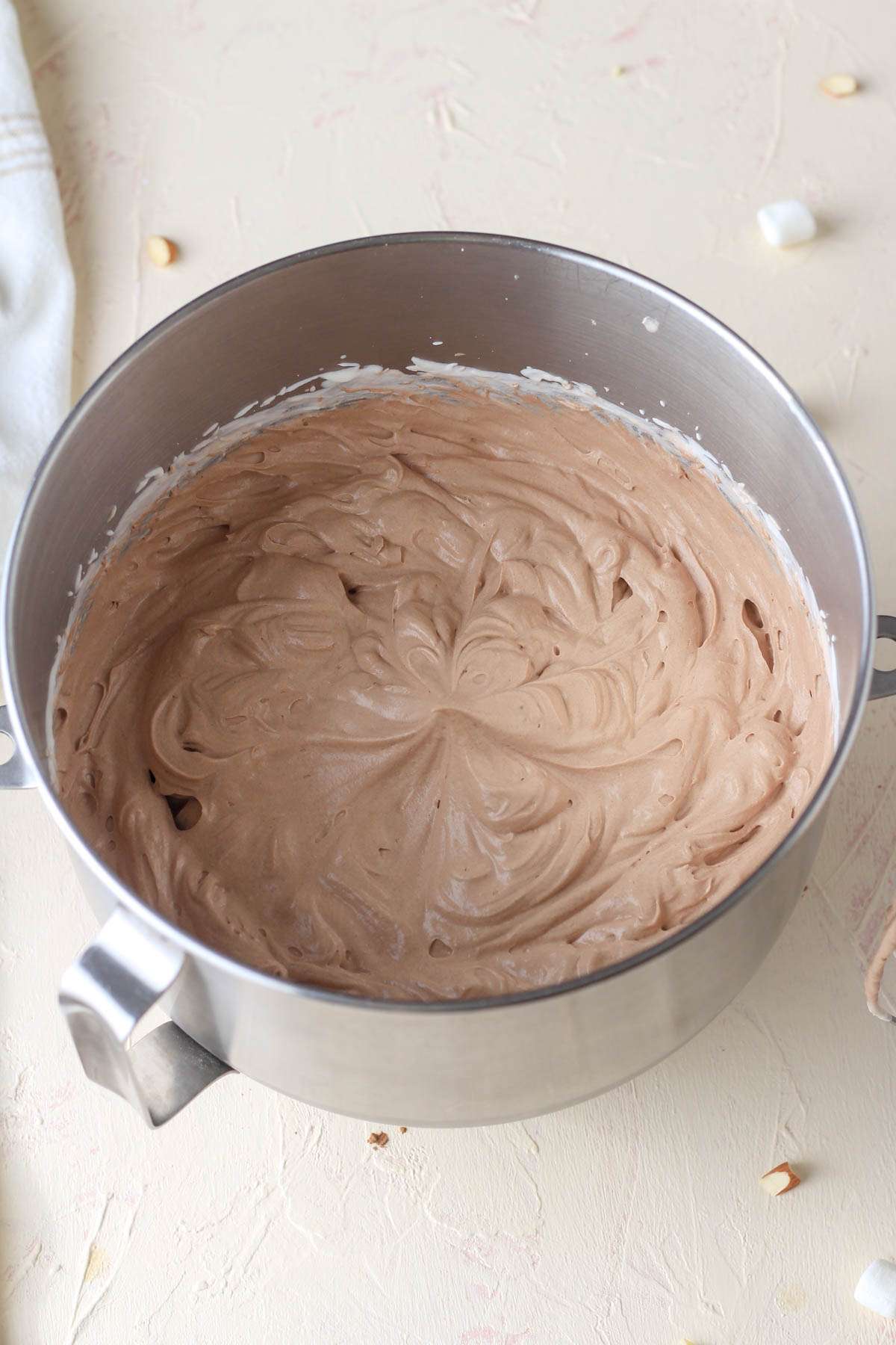 A silver mixing bowl with chocolate ice cream mixed together.