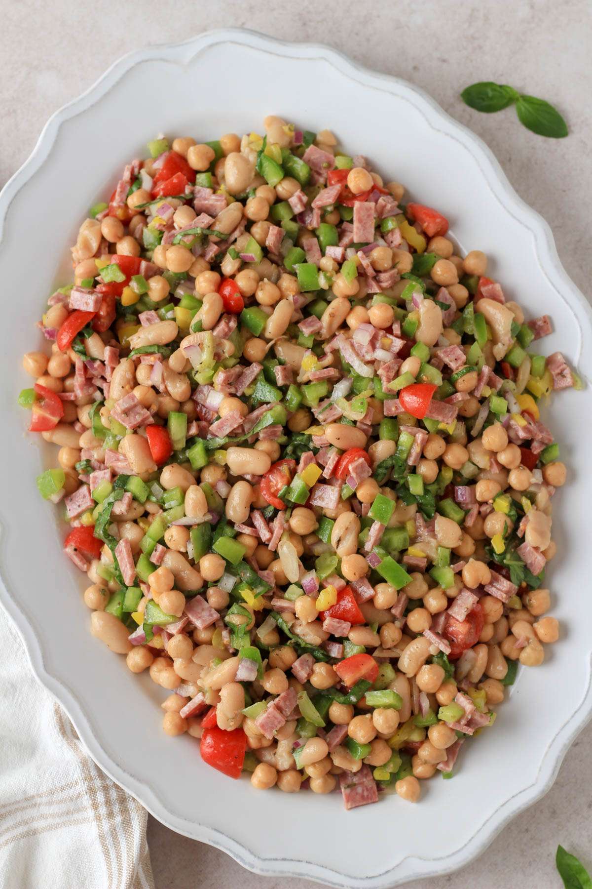 A large white platter with Italian grinder bean salad.