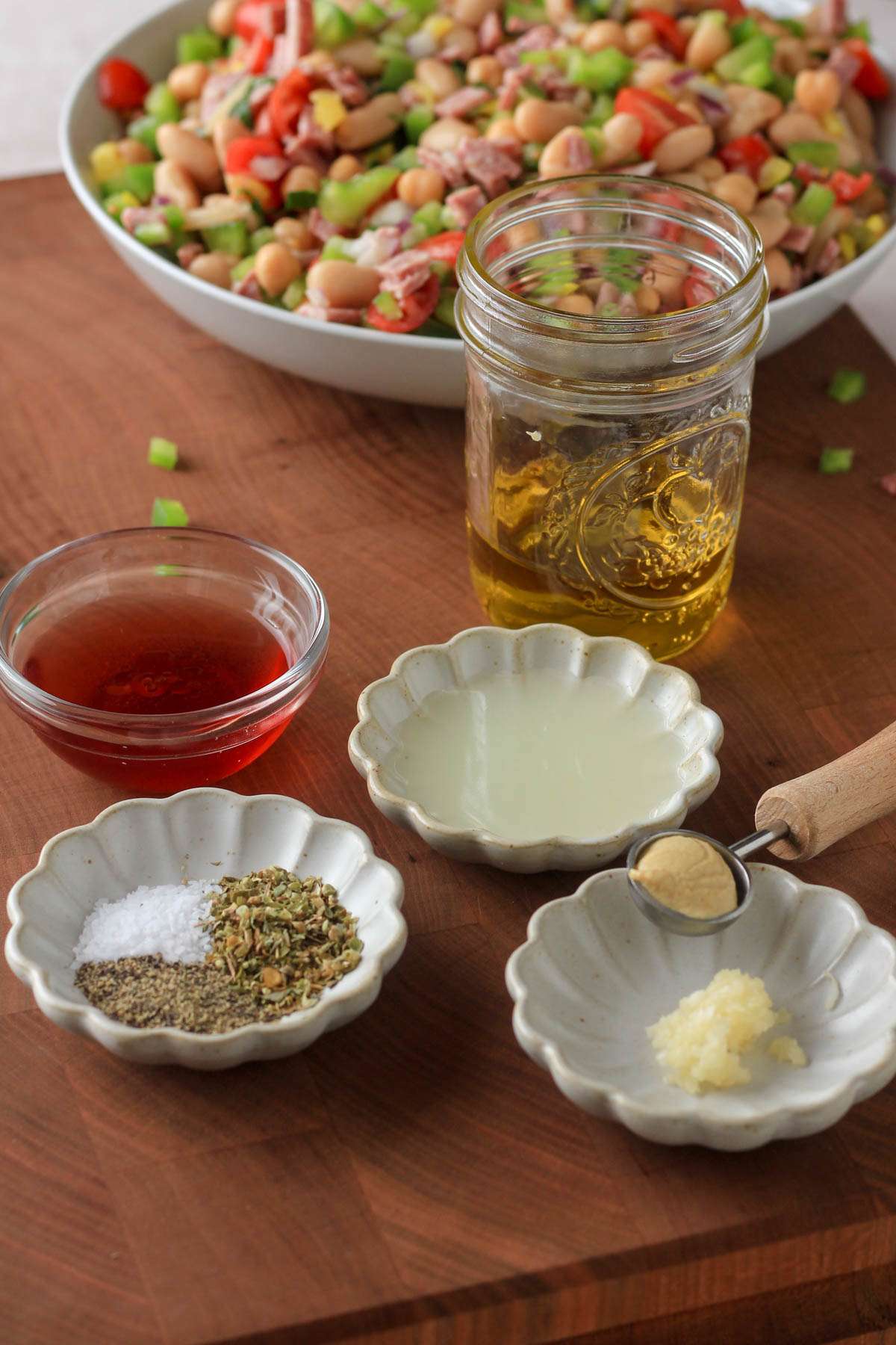 Ingredients for Italian dressing on a wooden cutting board.